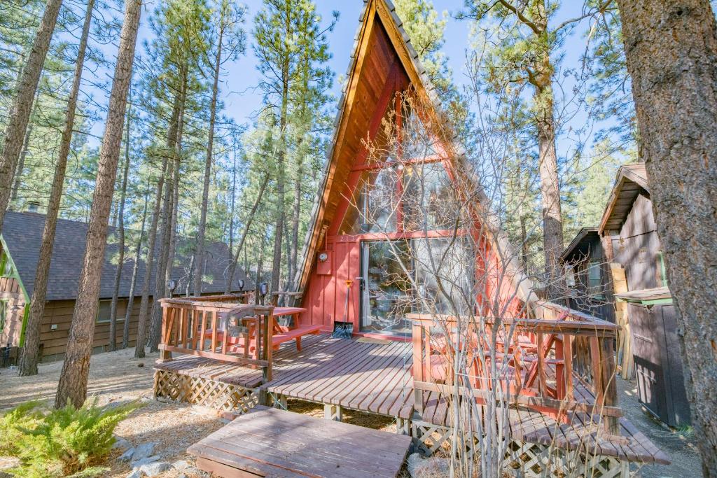 uma casa na árvore com um deque na floresta em A-Frame of Mind - Nice cozy cabin great view to the outdoors and peaceful em Big Bear City