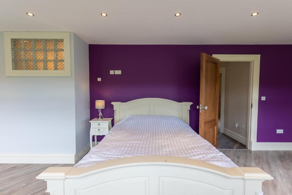 的住宿－Bellair House，卧室配有白色床和紫色墙壁