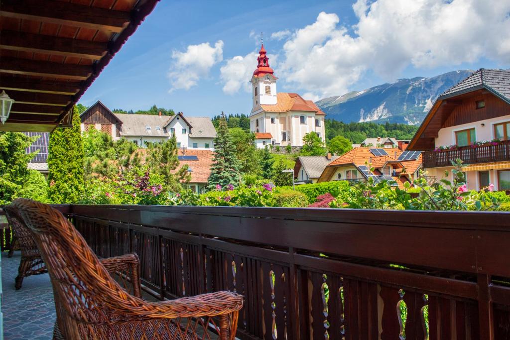 a balcony with a chair and a view of a town at La casa verde in Bled-Rečica