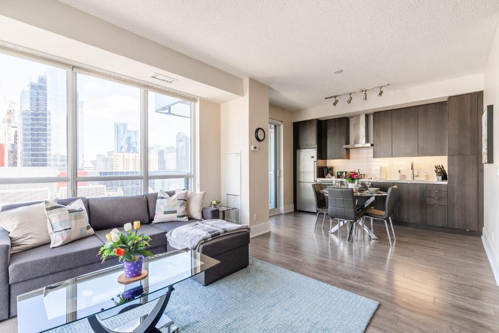a living room with a couch and a kitchen at Luxury 1BR Condo - King Bed - Stunning City Views in Toronto