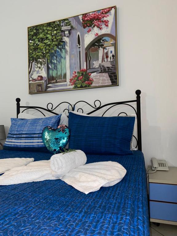 a blue bed with blue sheets and blue pillows at Rethymno Blue Apartments in Rethymno Town