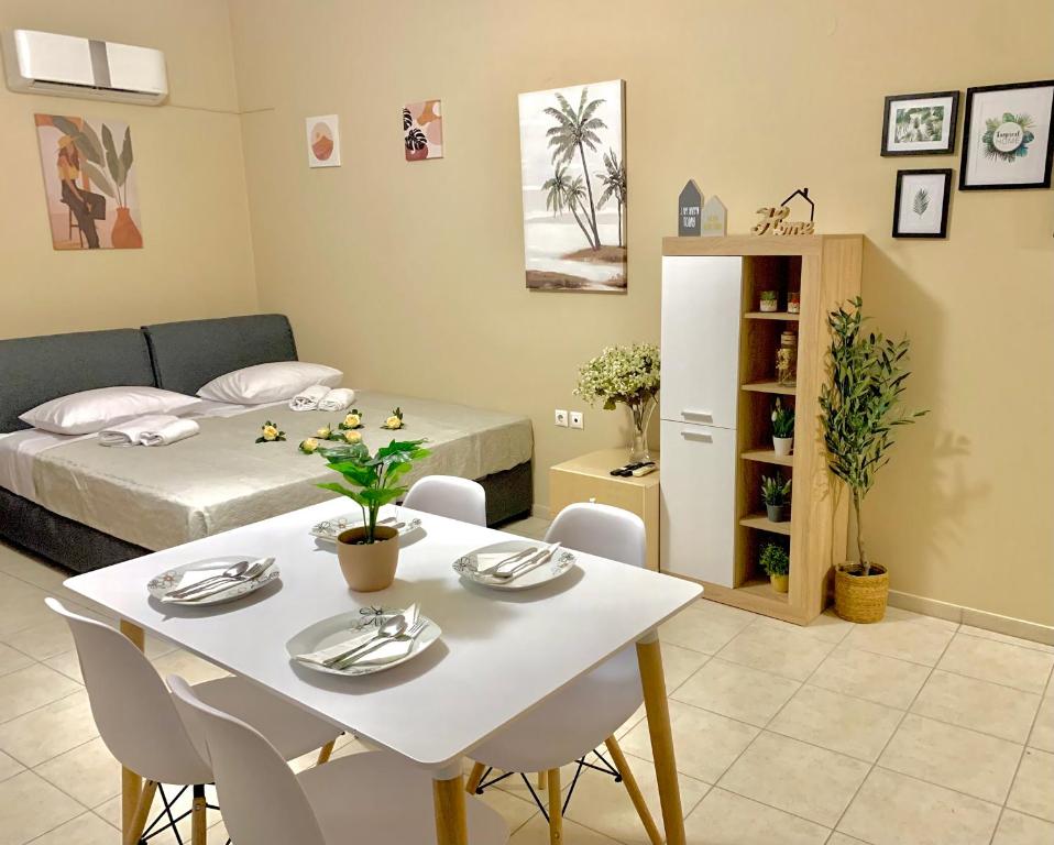a room with a table and chairs and a bed at George Airport Apartments in Heraklio