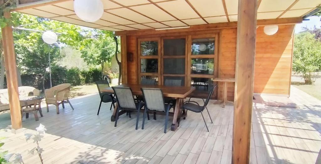eine Holzterrasse mit einem Holztisch und Stühlen in der Unterkunft ARTEMIS in Svoronata