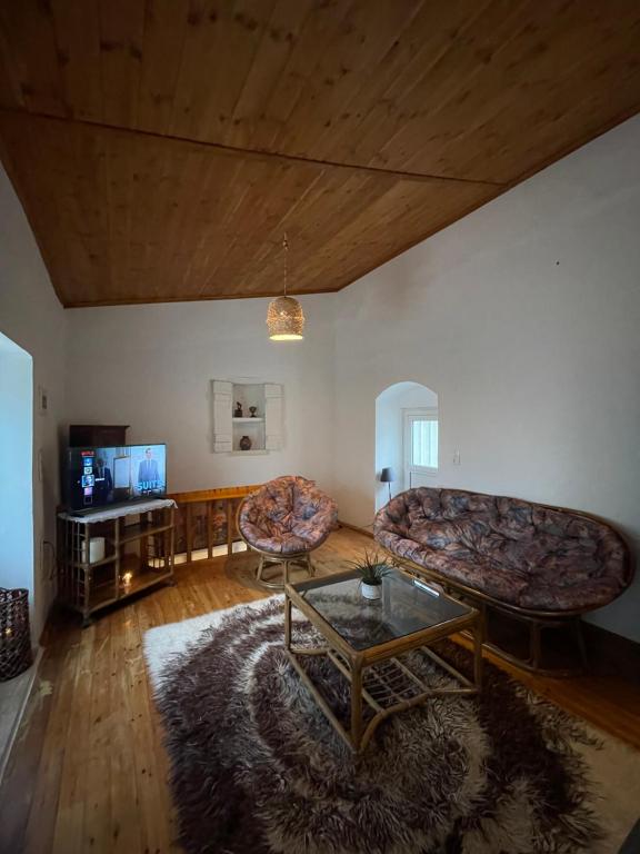 a living room with two couches and a table at Loft for travellers in Vasilikí