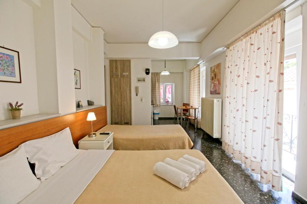 um quarto de hotel com duas camas e uma mesa em Selana Apartments em Mytilini