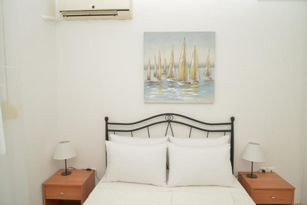 Unique Home في كانوني: غرفة نوم بسرير مع شراشف بيضاء ومصباحين
