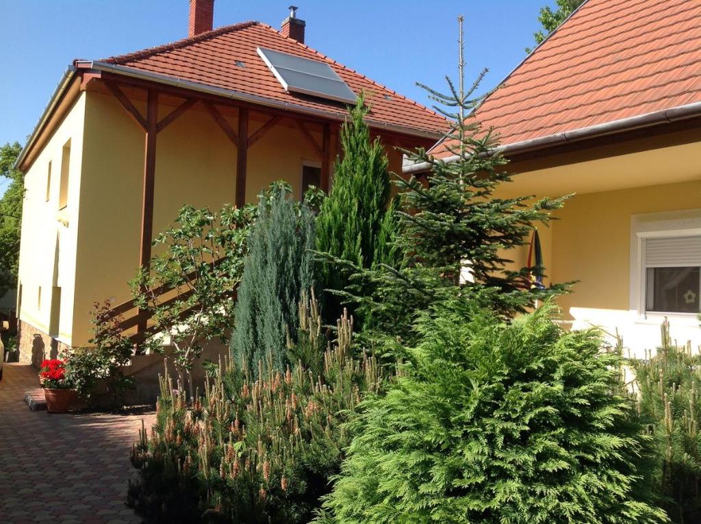 een tuin voor een huis met planten bij Honvéd Apartmanház in Hévíz