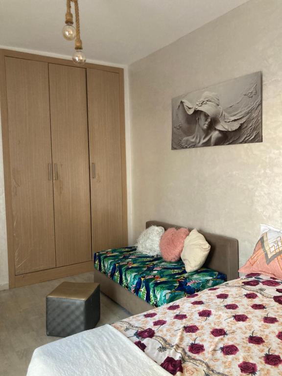 a bedroom with a bed and a couch and a cabinet at Spacious appartement of two rooms close to morocco mall in Casablanca