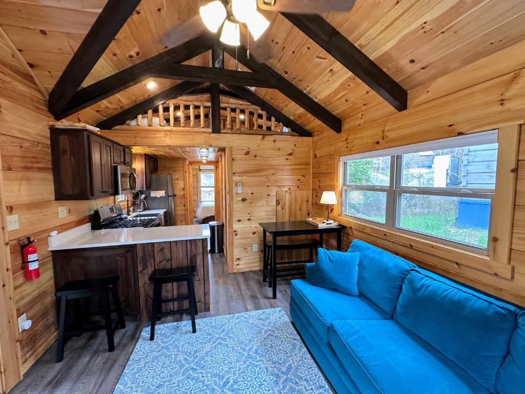 una sala de estar con un sofá azul en una cabaña de madera en BMV8 Tiny Home village near Bretton Woods en Twin Mountain
