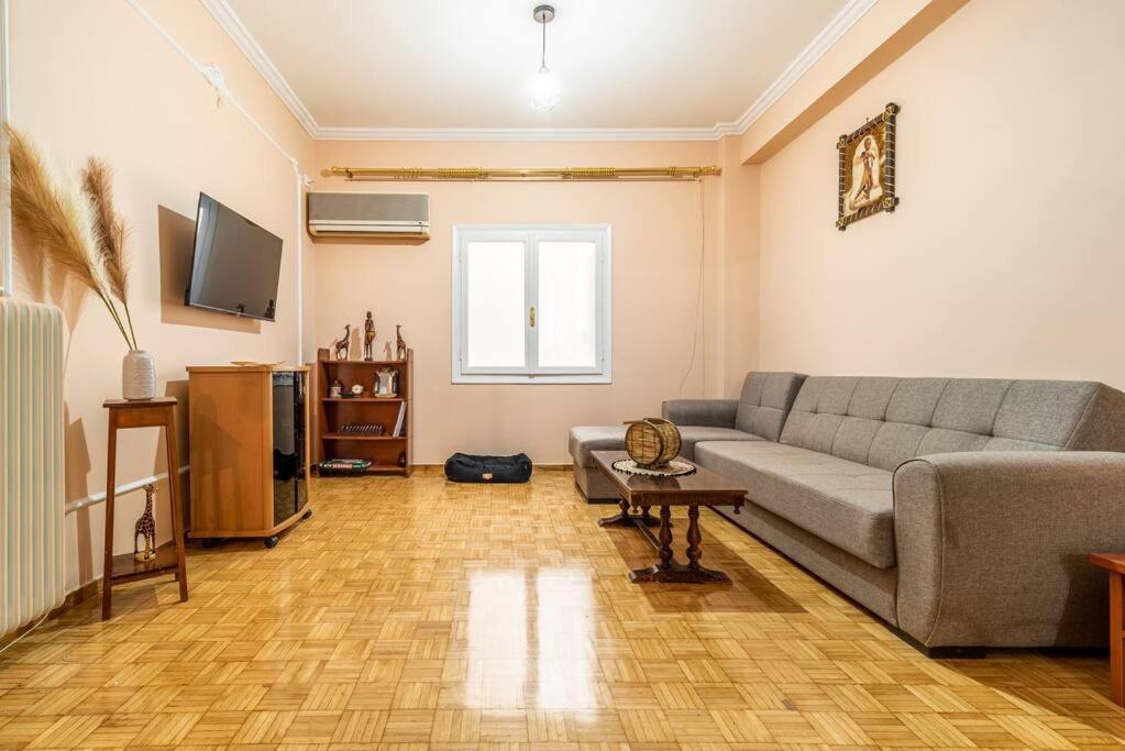 sala de estar con sofá y TV en Modern African-inspired flat en Atenas