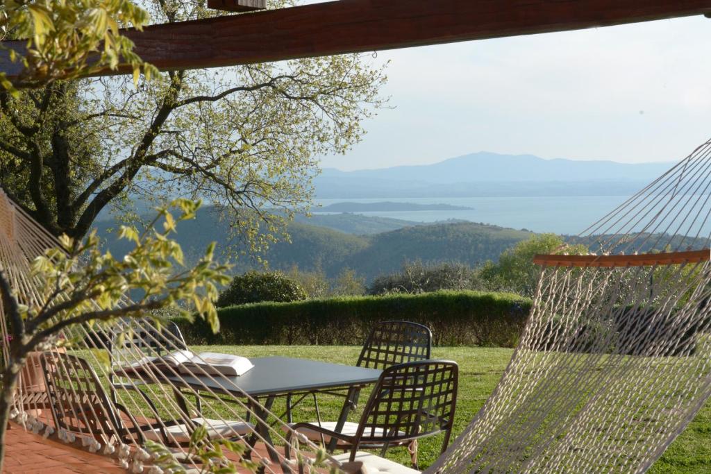 un patio con tavolo, sedie e vista di Agriturismo La Bicocca - Apt L'Olivo a Castel Rigone