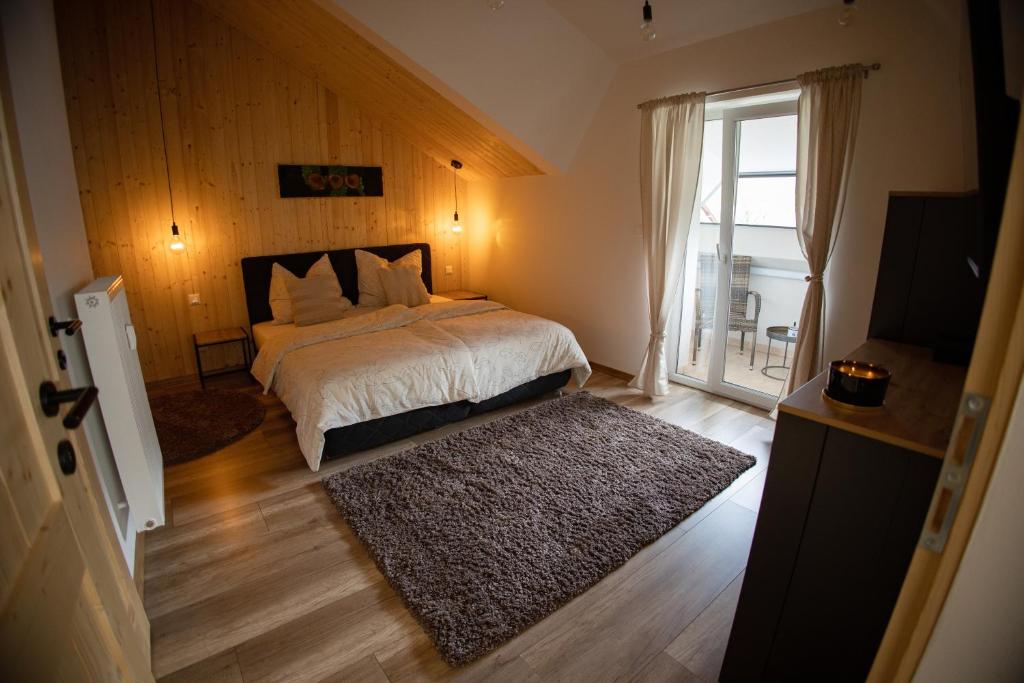 - une chambre avec un lit et une grande fenêtre dans l'établissement Apartmán Timea, à Terchová