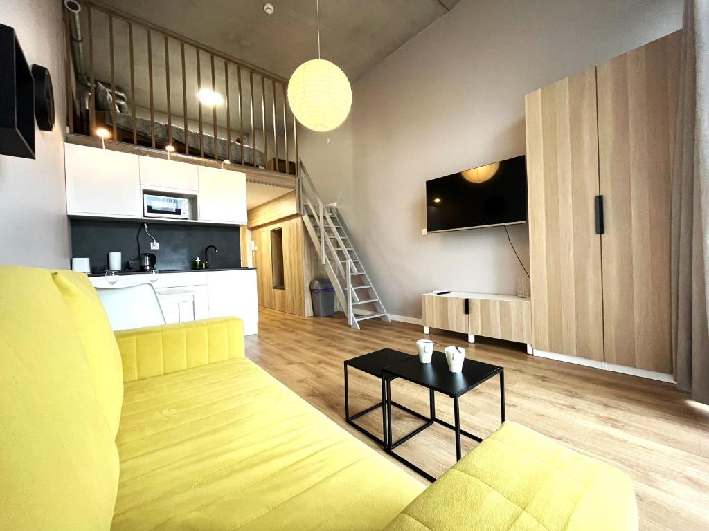 a living room with a yellow couch and a kitchen at Zarembowicza A36 Apartment - Self Check-In 20h - Parking &Lift in Wrocław