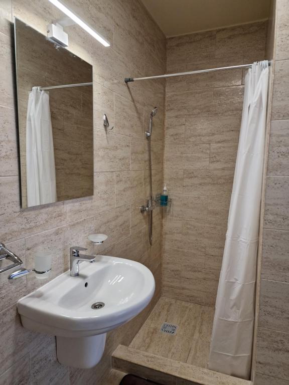 a bathroom with a sink and a shower with a mirror at Studio 58 Costinesti in Costinesti