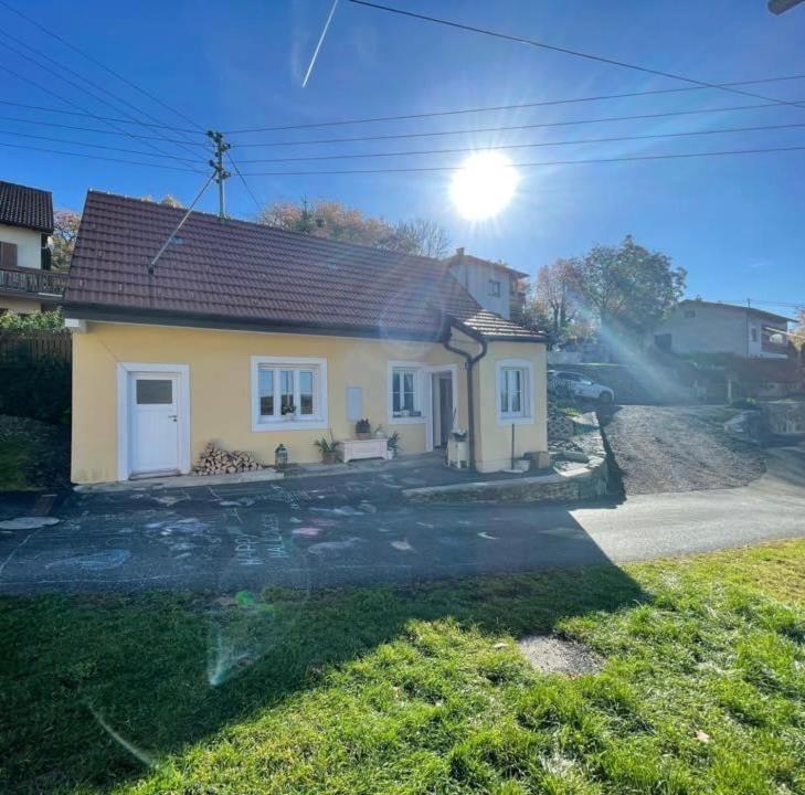 una pequeña casa amarilla con el sol en el cielo en Meli´s Zirbenbett Ferienhaus en Bernstein