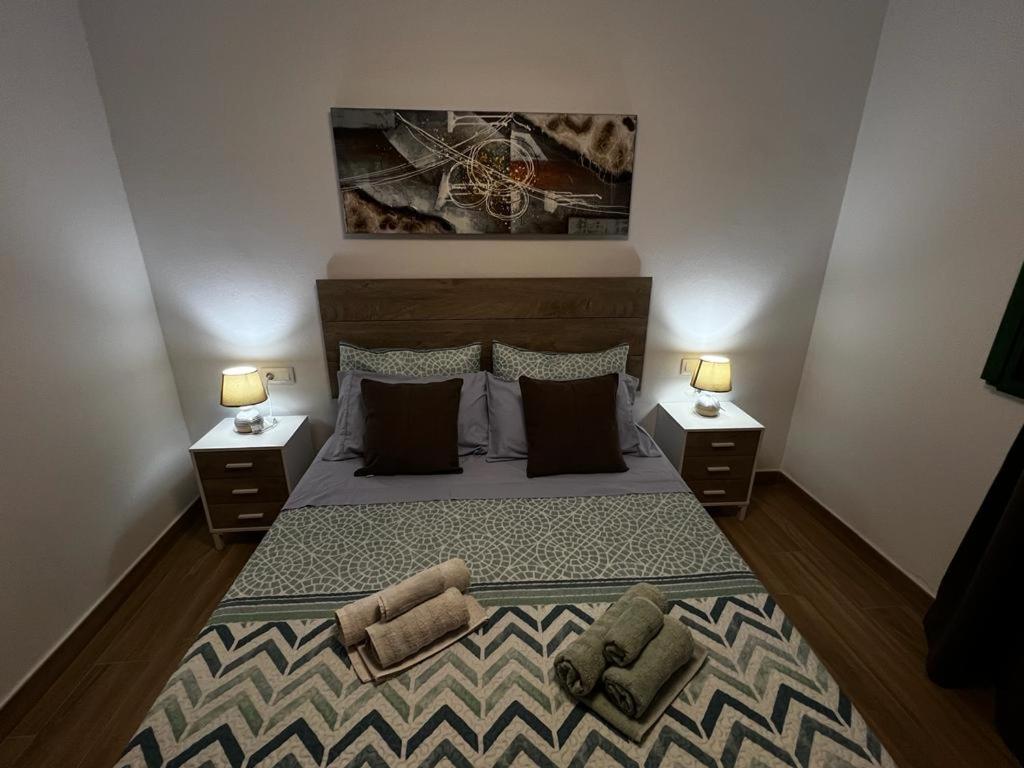 a bedroom with a large bed with two night stands at El Caseto in Costa Calma
