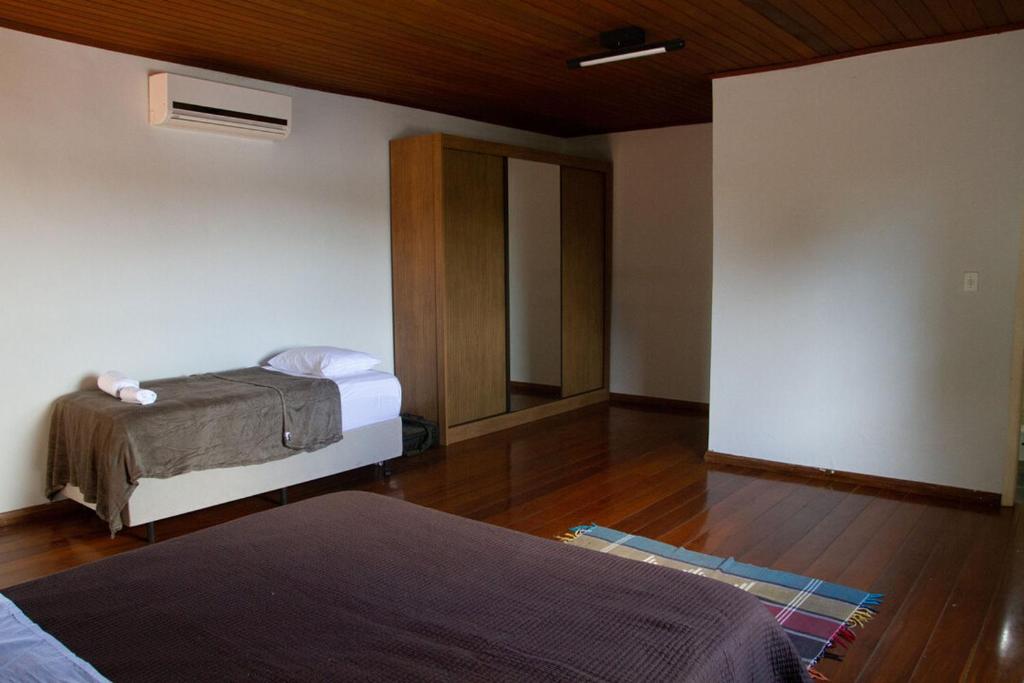 um quarto com 2 camas e piso em madeira em Casa com piscina e churrasqueira em Lagoa Santa MG em Lagoa Santa
