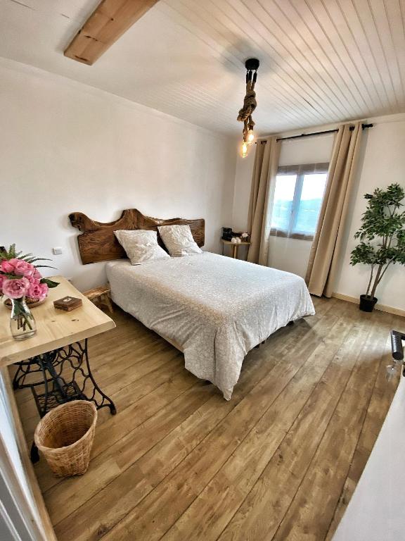 a bedroom with a large bed and a table at U PASTURELLU in Pioggiola