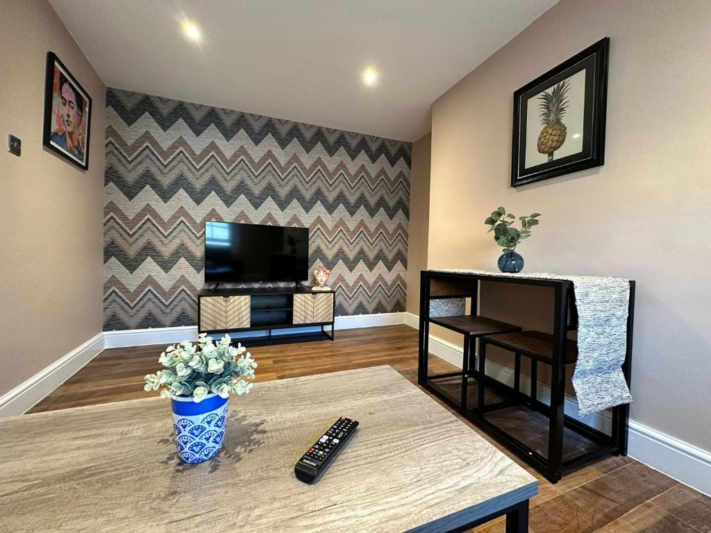 un soggiorno con TV e tavolo di Funky 1 Bedroom Apartment Next to the Sea a Brighton & Hove