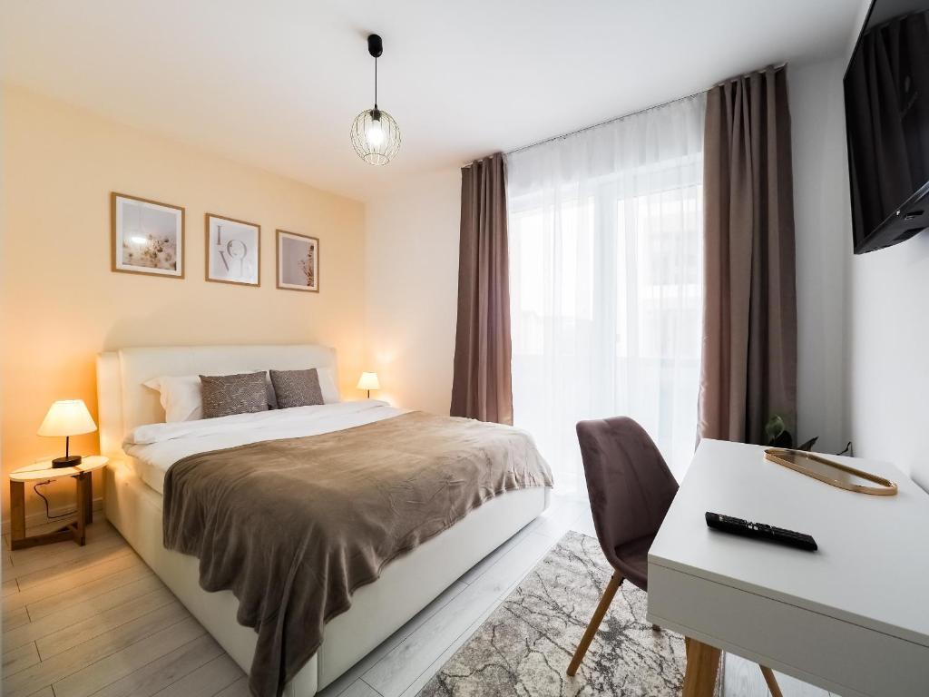 een slaapkamer met een bed, een bureau en een raam bij Bohemian Bliss in Sibiu