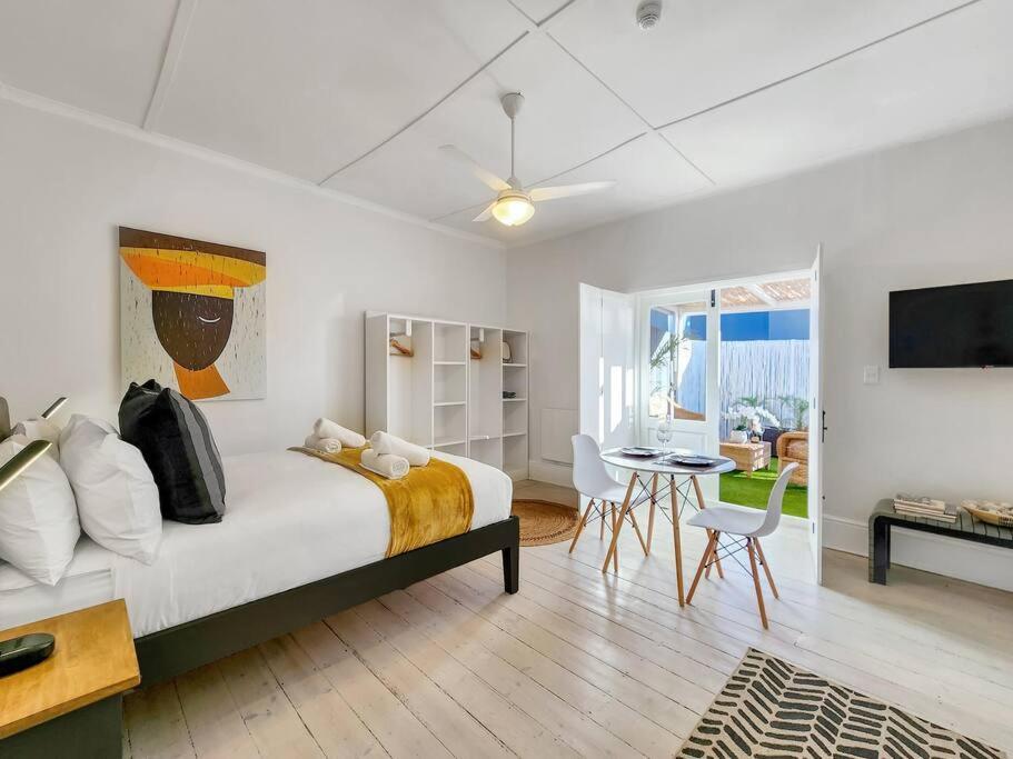 um quarto com uma cama e uma mesa com cadeiras em Visually Stunning apartment na Cidade do Cabo