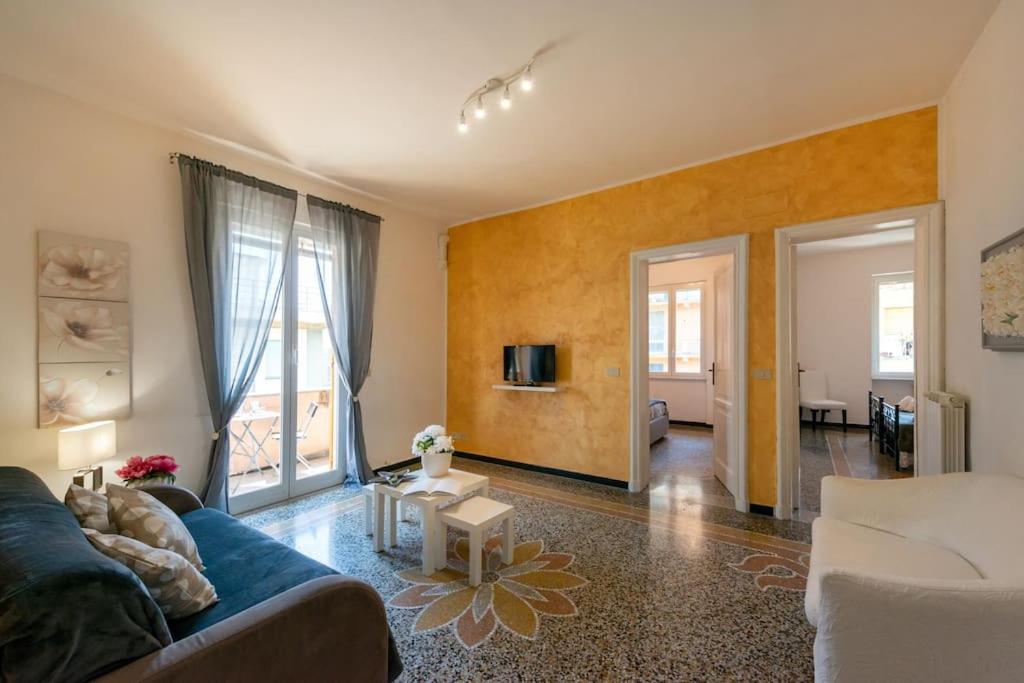 a living room with a blue couch and a tv at Casa Daniele - Centralissima sul porto di Rapallo in Rapallo