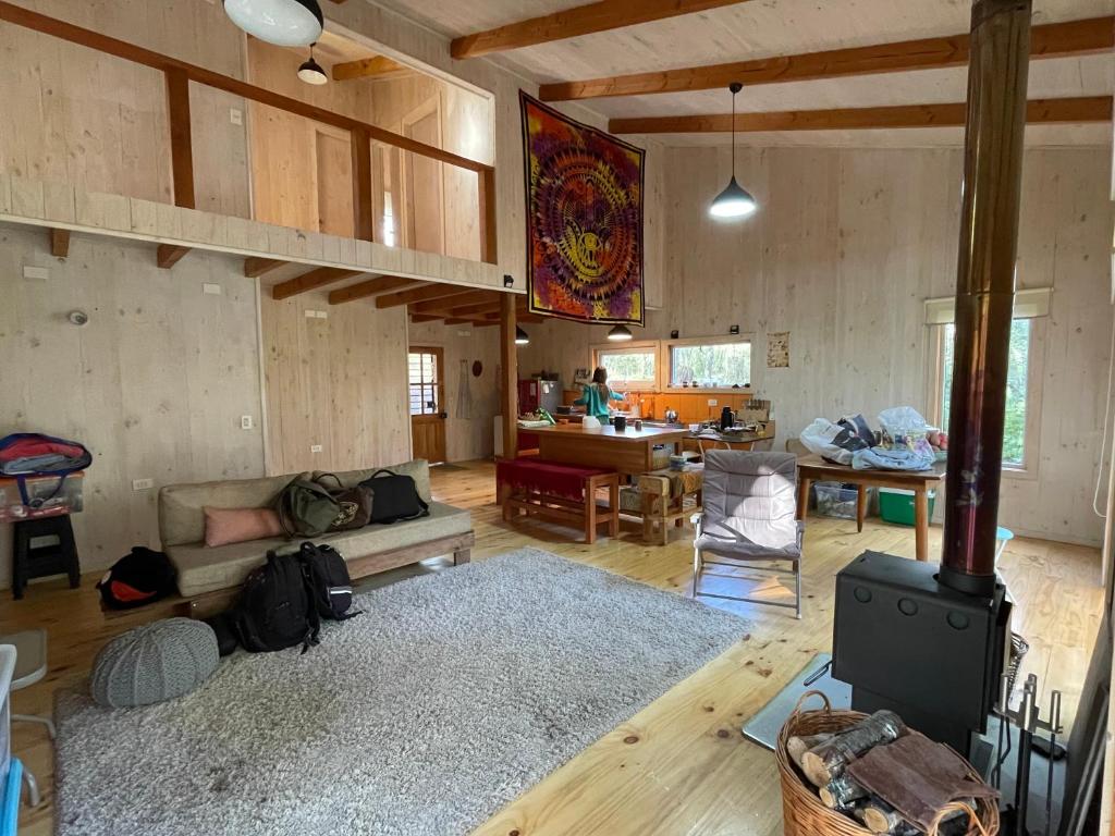 a living room with a couch and a stove at Cabaña Icalma, ahora con Tinaja in Curacautín