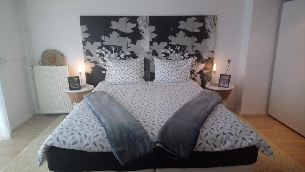 um quarto com uma cama grande e um cobertor preto e branco em B en B En Route em Berg en Terblijt