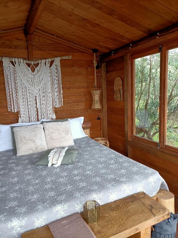 una camera da letto con un letto in una cabina di legno di The Treehouse - Casa sull'albero al Golden Camp a Falerna