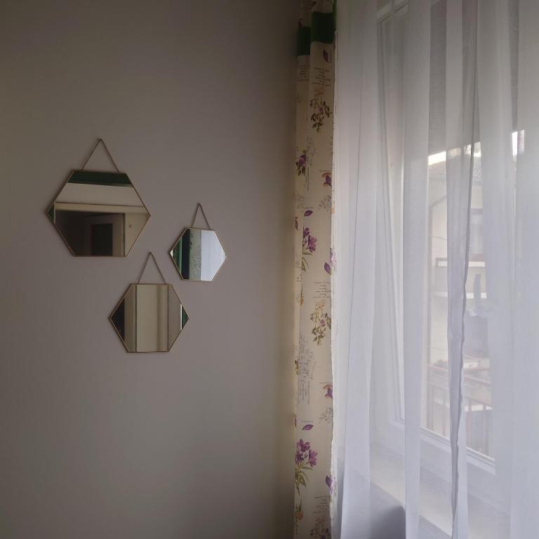 un espejo colgado en una pared junto a una ventana en appartamento 'Il glicine' en Valli del Pasubio