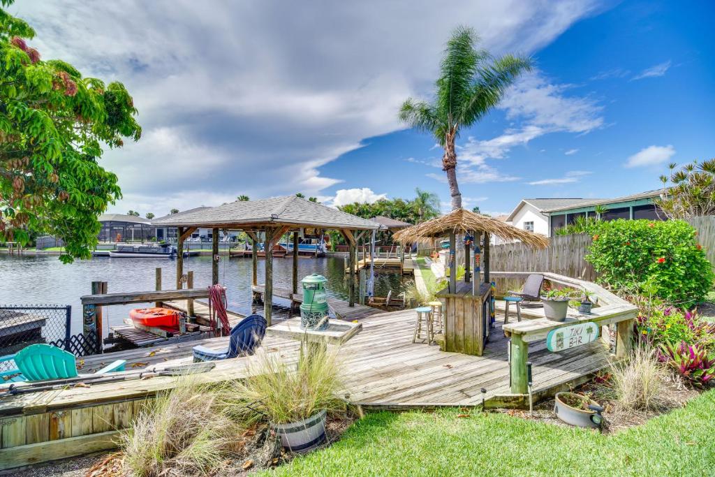 a wooden dock with a gazebo and a boat at Waterfront Merritt Island Vacation Rental with Pool! in Merritt Island