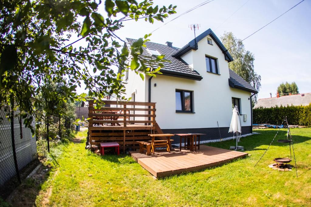 a backyard with a table and benches and a house at Domek Breloka in Buczkowice