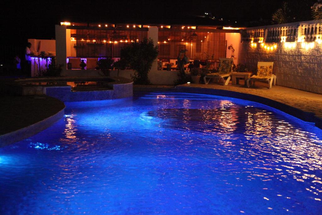 een zwembad verlicht in de nacht met blauwe lichten bij The Dragonfly Retreat in Málaga