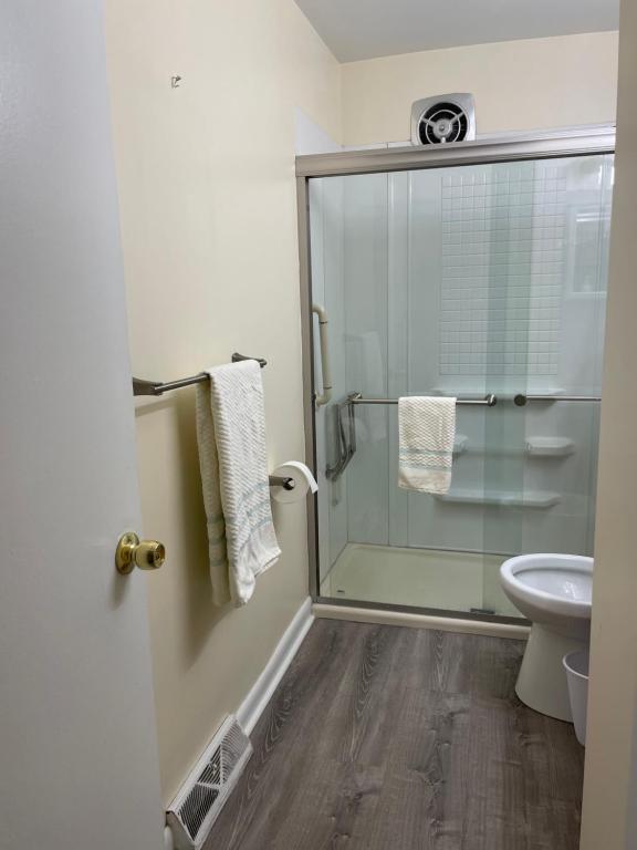 La salle de bains est pourvue d'une douche en verre et de toilettes. dans l'établissement Quiet 2 Bedroom Apartment Condo in the Hampden / Medfield area few minutes to Downtown - Emerald Elite, à Baltimore