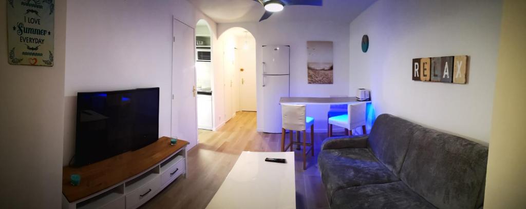 un salon avec un canapé et une table dans l'établissement Appartement avec piscine et garage proche plage et commerces, à La Seyne-sur-Mer