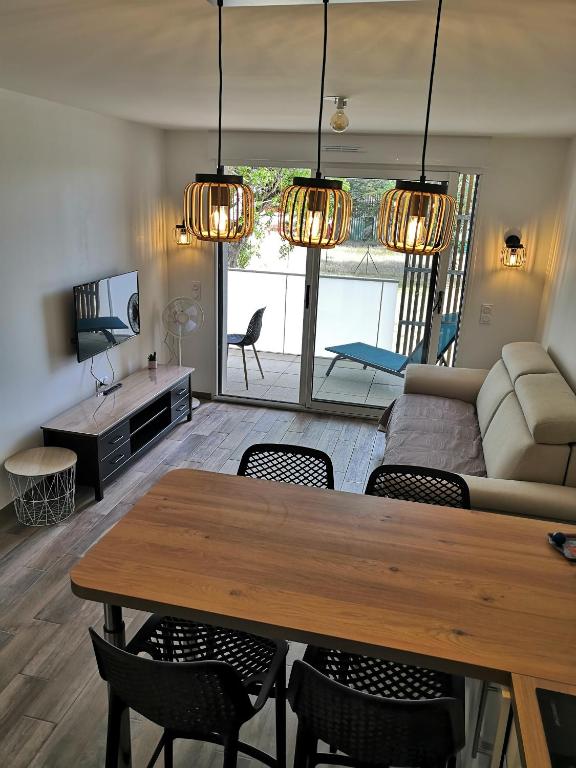 un salon avec une table et un canapé dans l'établissement Appartement neuf 40 m² 300 m de la mer, à Saint-Jean-de-Monts