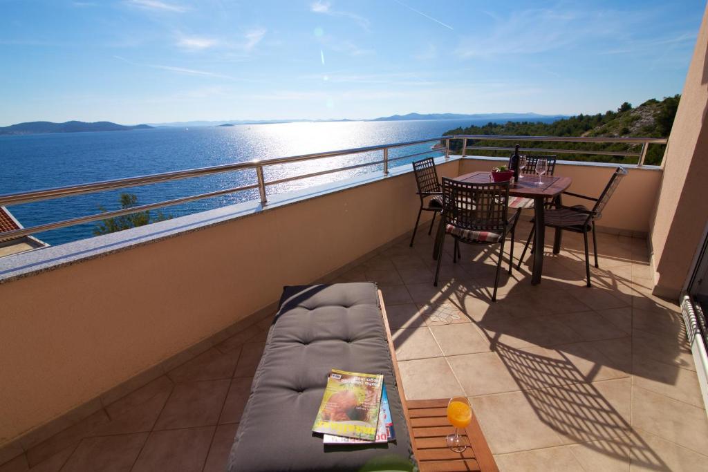 einen Balkon mit Sofa und Tisch und Blick auf das Wasser in der Unterkunft Lea Apartments in Drage