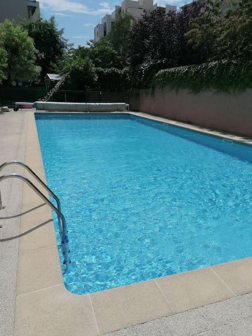 une grande piscine bleue dans un immeuble dans l'établissement Appartement de charme, Garage, Terrasse, Piscine, à Lyon