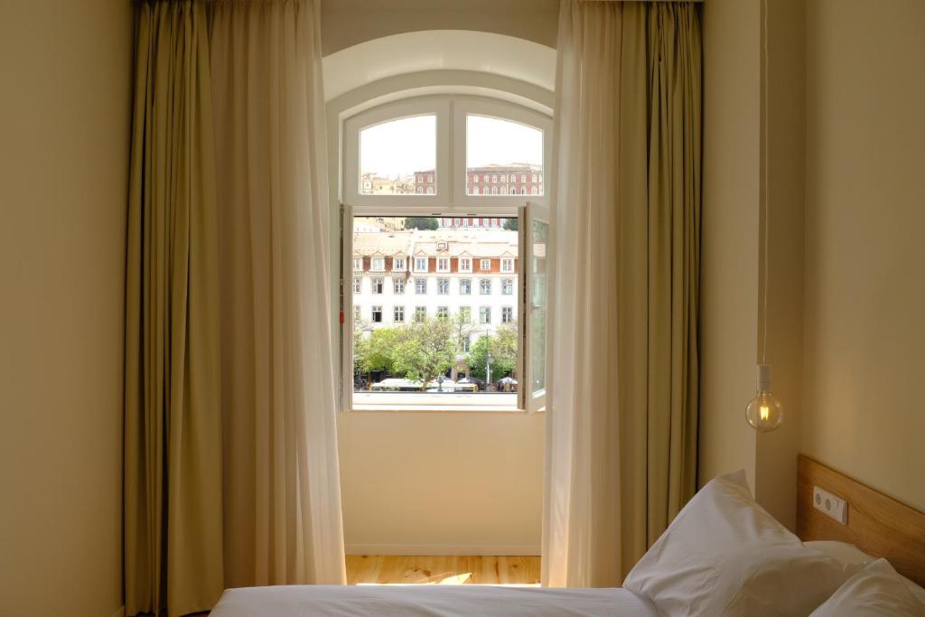 a bedroom with a window with a view of a building at Liberator Rossio in Lisbon