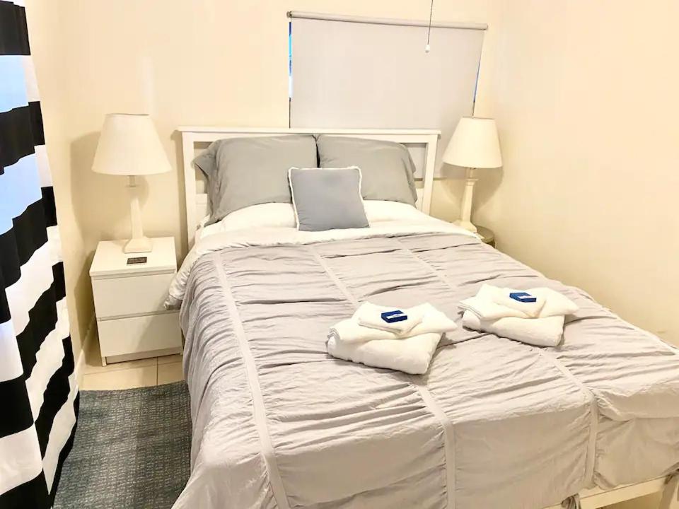 a white bed with two towels on top of it at Private Rooms close to Miami Airport - Free parking - 02 in Miami