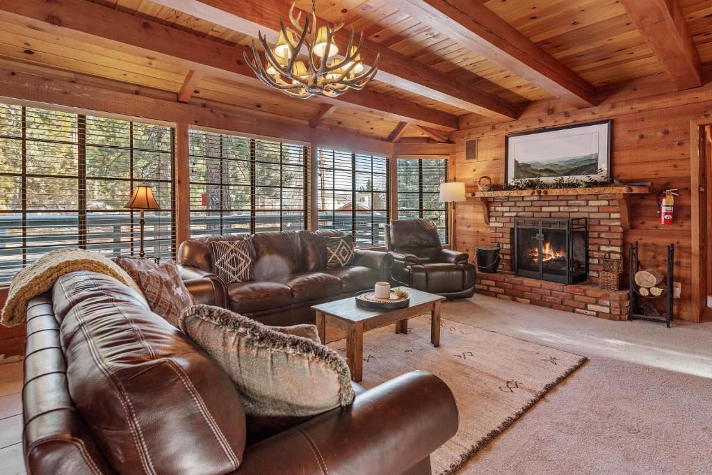 sala de estar con muebles de cuero y chimenea en The Lakehouse Cabin - Located close to the Lake! Hot Tub, Smart TV, and WiFi! en Big Bear Lake