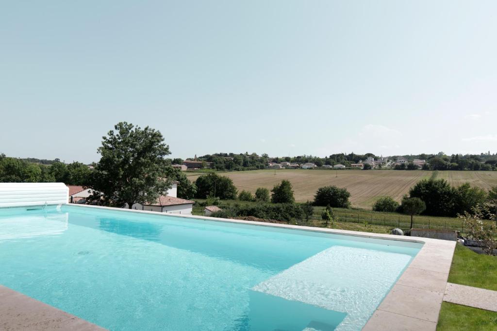 una piscina con vista su un campo di Les Coteaux de Toulouse a Aureville