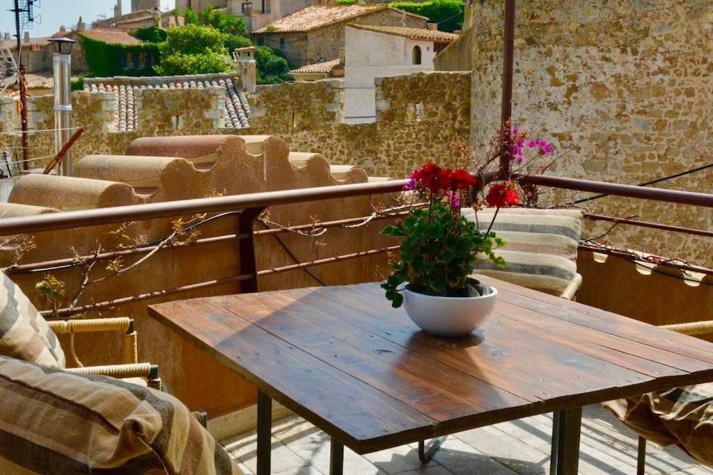einem Holztisch mit Topfpflanze auf dem Balkon in der Unterkunft Can Senio 3 in Tossa de Mar