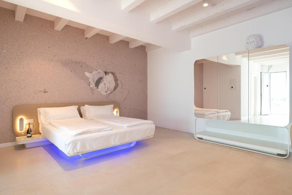 a bedroom with a bed and a mirror at Unico Hotel Caorle in Caorle