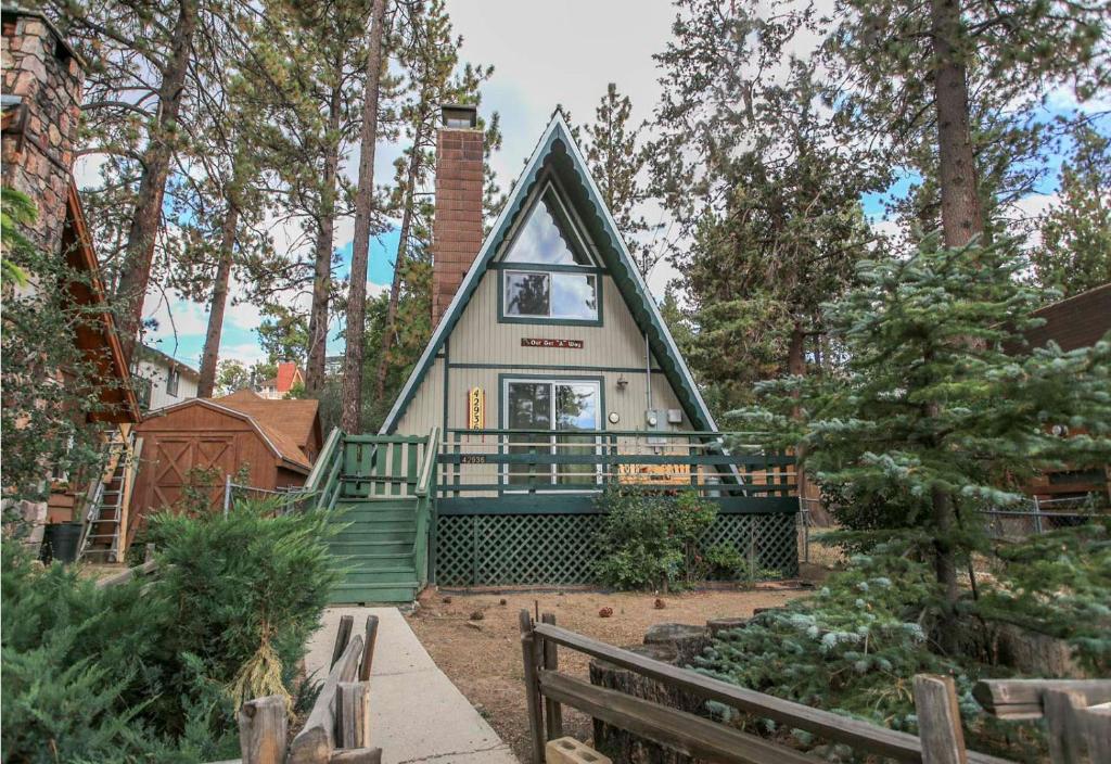 a house in the woods with a green roof at The Getaway - Amazing and cozy escape! With beautiful views of the Bear Mountain slopes! in Big Bear Lake