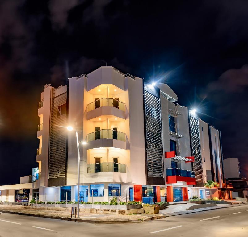 un edificio blanco alto con luces de la calle delante de él en Hotel Miraval, en Montería