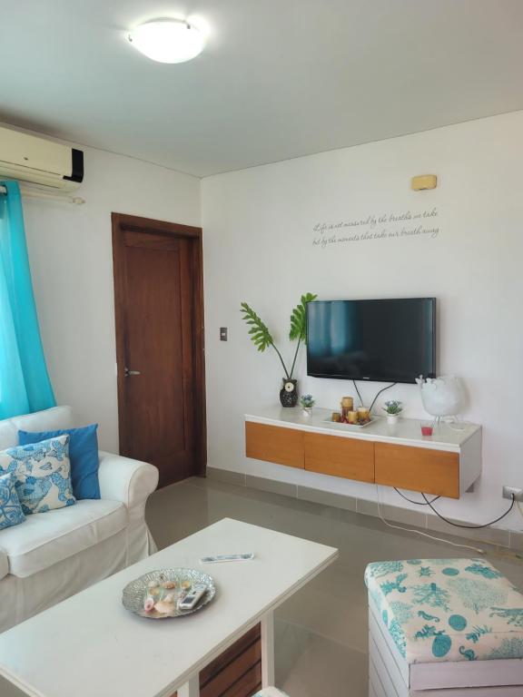 a living room with a couch and a tv at Serena star3 in Punta Cana