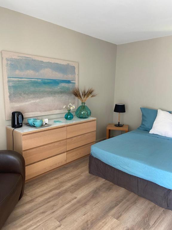 a bedroom with a bed and a painting of the ocean at Embruns et Sarrasin in Combrit