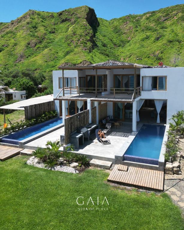 a house with a swimming pool and a mountain at Gaia - Casa de Playa in Canoas de Punta Sal