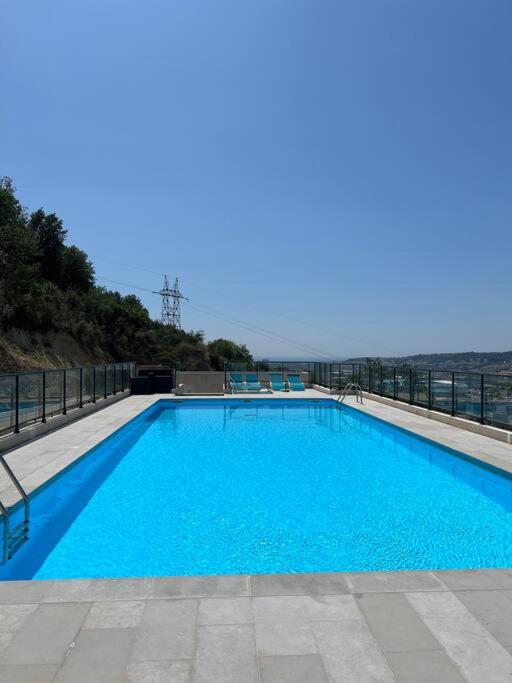 a large blue swimming pool on top of a building at Très joli 2 pièces calme ensoleillé avec piscine in Nice